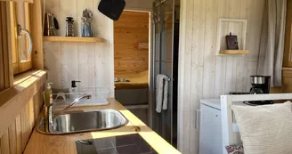 Roulotte minimaliste, construite en matériaux naturels et sa kitchenette