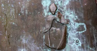 Détail porte en cuivre avec personnages gravés_3